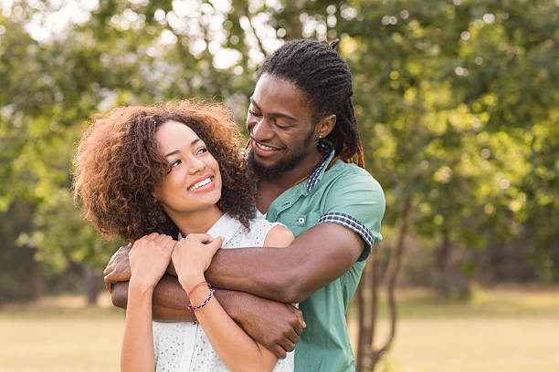 istock Cute couple in the park making heart shape 473939864
