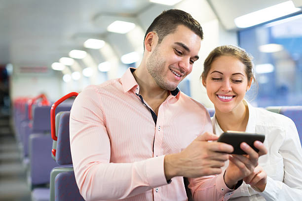 istock Young couple with smartphones in train 473940634