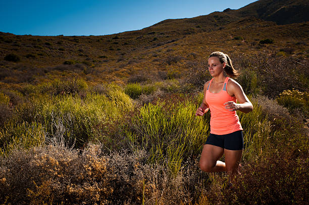 istock Blonde female trail runner running through a mountain landscape 473946892