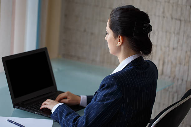 istock Businesswoman typing on laptop side view 473947308