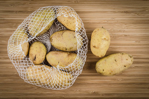 Raw potatoes on a rustic wooden table. Photo made with high quality photo equipment in a modern photo studio. 