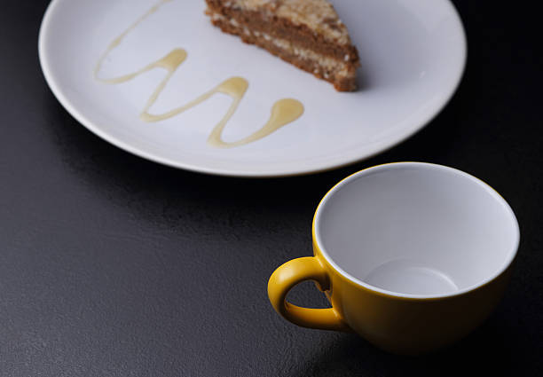 istock Cake on round white plate and yellow cup 473947710