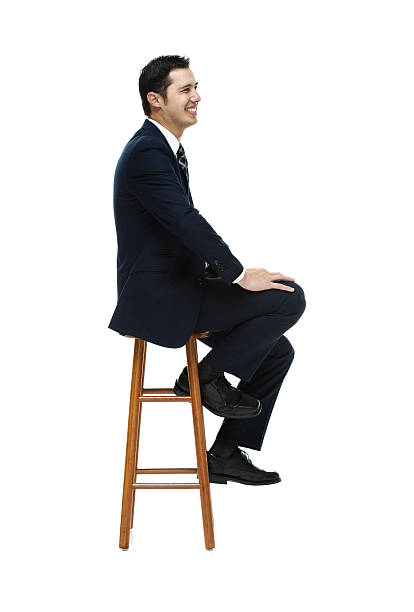istock Cheerful businessman on stool and looking away 473947920