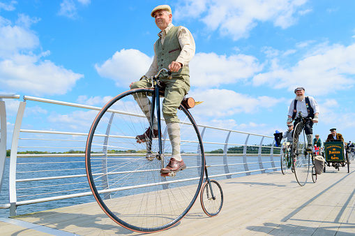 Solvesborg, Sweden - May 16, 2015: International Veteran Cycle Association (IVCA) 35th rally. Costume ride through public streets in town. Senior man on penny-farthing.