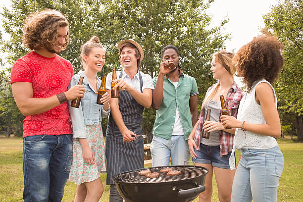 Happy friends in the park having barbecue on a sunny day