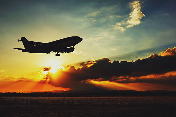 Silhouette of an airplane landing. stock photo