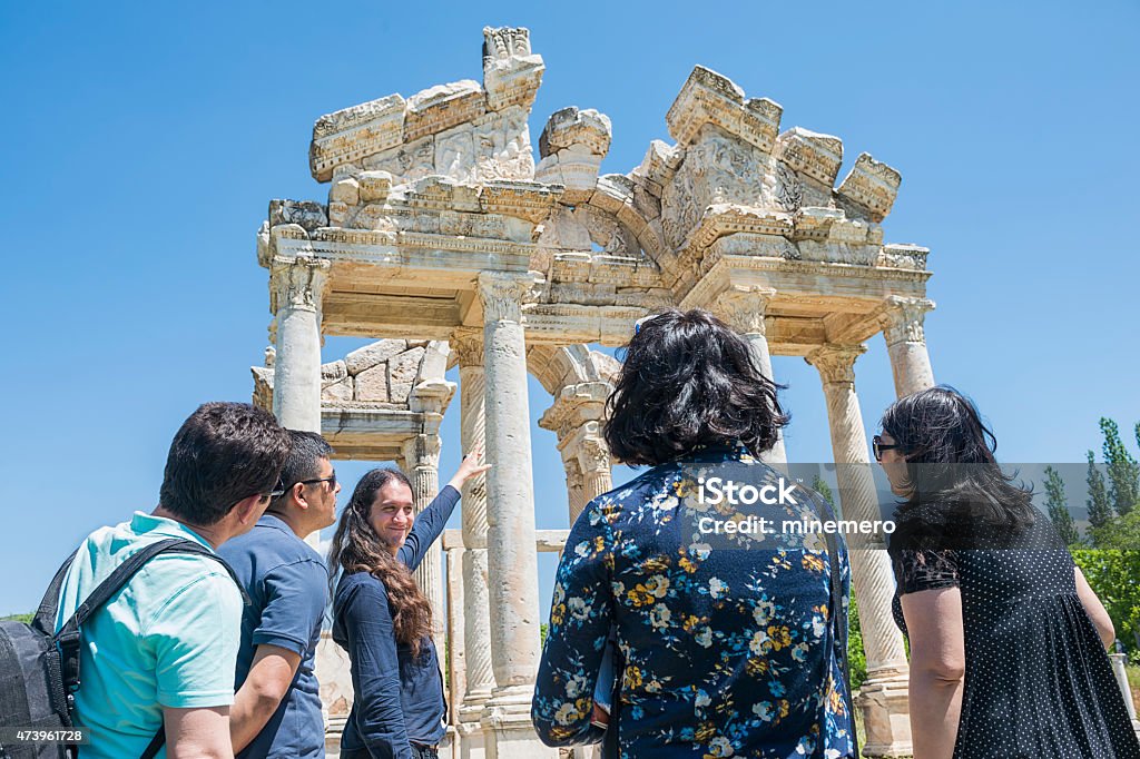 Guida e turisti davanti all'Tetrapylon di Afrodisia, - Foto stock royalty-free di Guida turistica - Professione