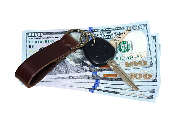 istock Car key on money isolated on white 473968826