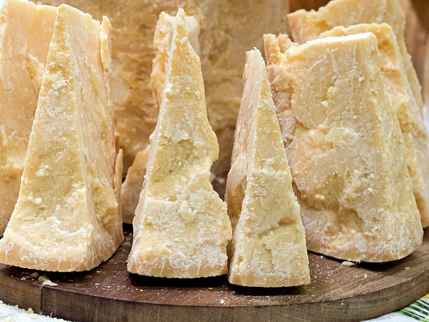 thick slices of Italian Parmesan cheese on  wooden cutting boar stock photo