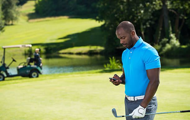 joueur de golf avec le téléphone intelligent - golf cart golf bag horizontal outdoors photos et images de collection