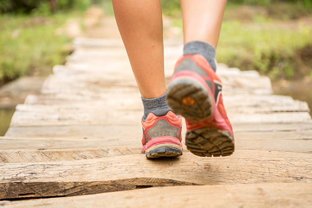 istock Human's feet crossing a wooden bridge 473994750