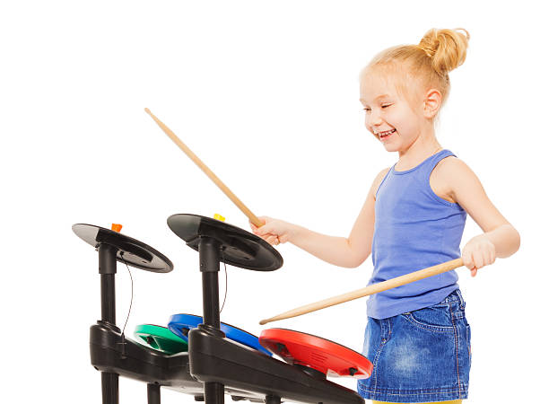 istock Cute small girl playing with drumsticks on cymbals 473999284