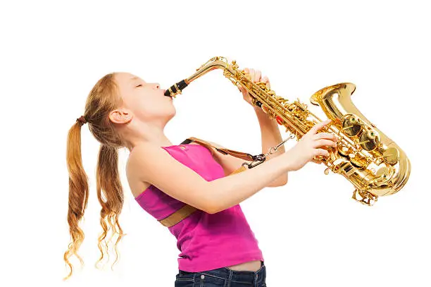 Happy girl playing alto saxophone on the white background