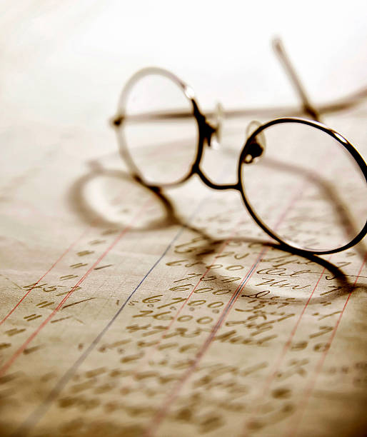 istock Eye glasses sitting on old hand written ledger. 474008780