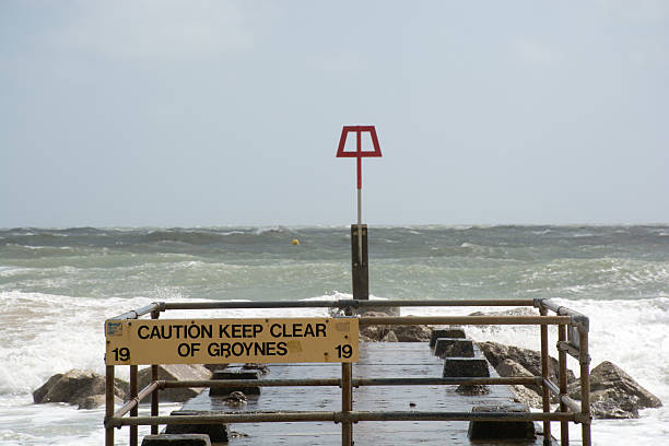 istock Warning sign on Groyne with rough sea in background 474011994