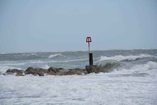 istock Rough seas surround this groyne UK beach 474014816