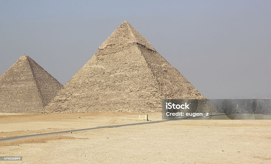 The Pyramids of Giza, Cairo, Egypt. The Pyramids of Giza consist of the Great Pyramid of Giza (known as the Great Pyramid and the Pyramid of Cheops or Khufu), the somewhat smaller Pyramid of Khafre (or Chephren) a few hundred meters to the south-west, and the relatively modest-sized Pyramid of Menkaure (or Mykerinos) a few hundred meters further south-west. The Great Sphinx lies on the east side of the complex. Current consensus among Egyptologists is that the head of the Great Sphinx is that of Khafre. Along with these major monuments are a number of smaller satellite edifices, known as "queens" pyramids, causeways and valley pyramids. Africa Stock Photo