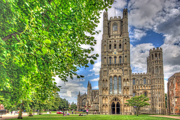 Ely Cathedral exterior Ely, United Kingdom - August 18, 2014: Ely Cathedral in Cambridgeshire taken from the open grass area surrounding it. This is a combination of 3 bracketed exposure 3 stops apart combined in HDR software to bring out detail in the shadows and the sky. ely england photos stock pictures, royalty-free photos & images