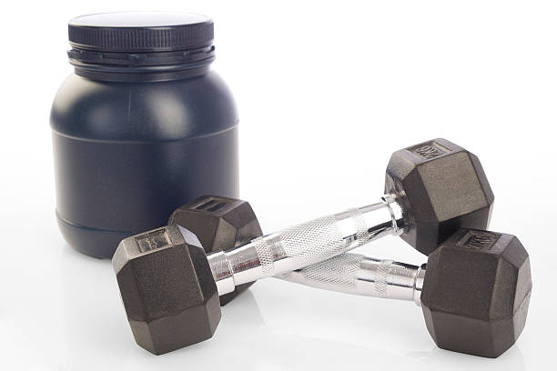 istock Isolated two dumbbells and protein powder bottle on white background 474039248