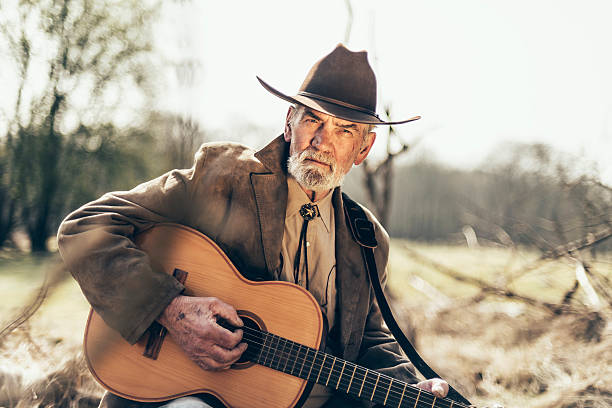 istock Senior man reminiscing as he strums a guitar 474043040