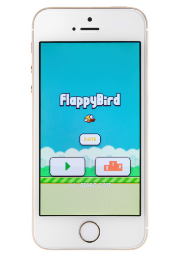 Canberra, Australia - February 19, 2014: Front view of the new Apple iPhone 5s gold version with Flappy Bird App showing the game ready to start, isolated on a white background.