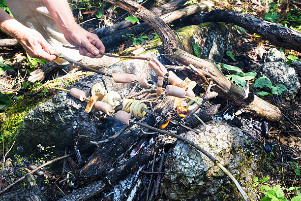 istock Cooking sausages, bread and onion on campfire during hiking 474044942