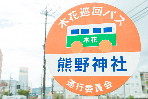 Japanese traffic sign for bus STOP at town Ibii, close to Miyazaki, Japan. Town in background.