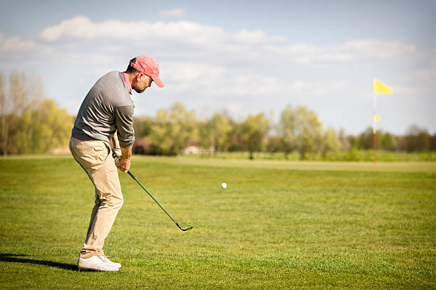 istock Male golf player pitching near green. 474055040