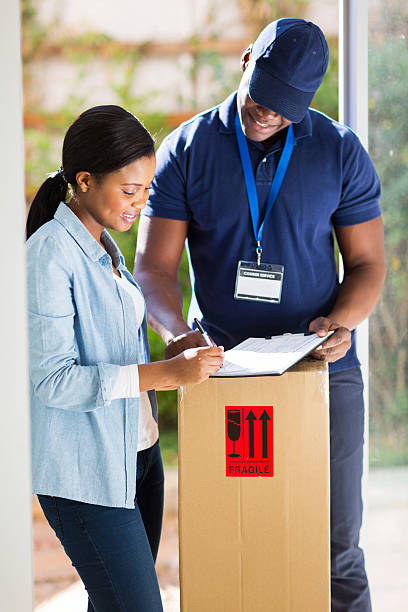 customer signing for delivery from courier beautiful customer signing for delivery from courier indigo truck stock pictures, royalty-free photos & images