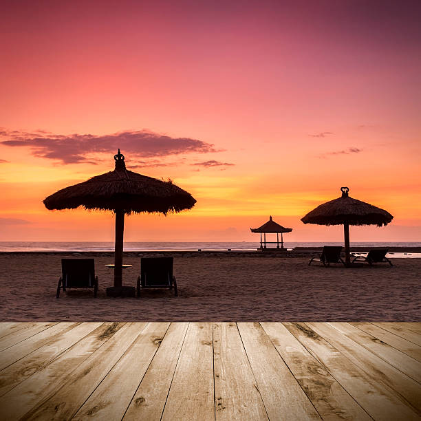 istock Empty wooden platform facing a sunrise with beach umbrella 474056644