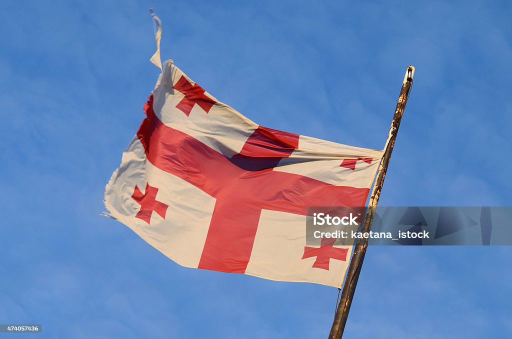 Old georgian national flag with red crosses and blue sky Old georgian national flag with red crosses and the blue sky 2015 Stock Photo
