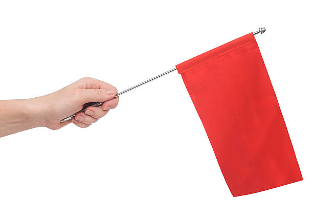 istock Hand holding a red flag isolated on white background. 474058353