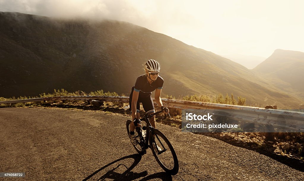 Racing towards her fitness goal Shot of a cyclist riding on a mountain roadhttp://195.154.178.81/DATA/i_collage/pu/shoots/804604.jpg Cycling Stock Photo