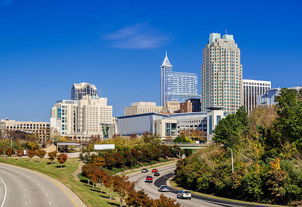Raleigh downtown skyline and street lined with Autumn colored trees Raleigh downtown skyline view with Mcdowell Street and Dawson Street in the foreground, lined with Autumn colored trees. raleigh north carolina stock pictures, royalty-free photos & images