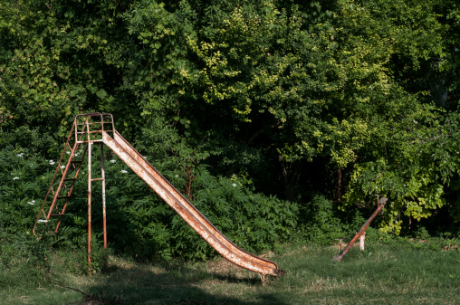 Vintage rusty slide at an abandoned playground.