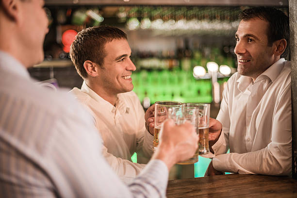 istock Smiling businessmen toasting with beer in a bar. 474067278