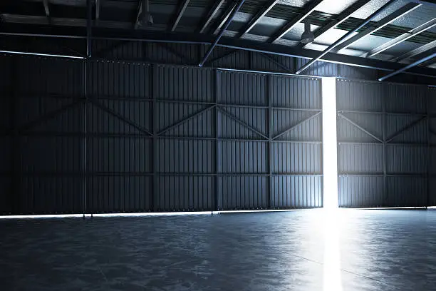 Empty building hanger with the door cracked open with room for text or copy space.Photo realistic rendering