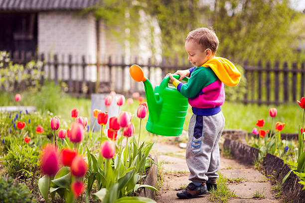 istock cute little boy watering flowers 474068672