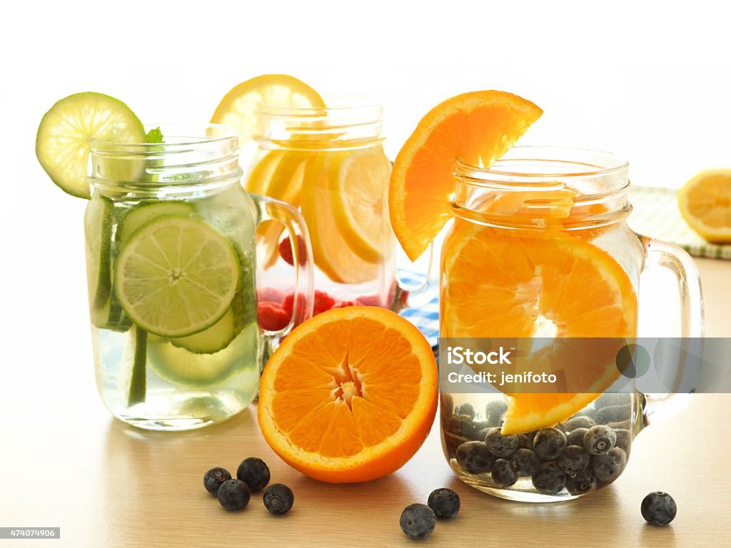 Detox water with various types of fruit in mason jars Detox water with various types of fresh fruit in mason jar glasses on a table 2015 Stock Photo