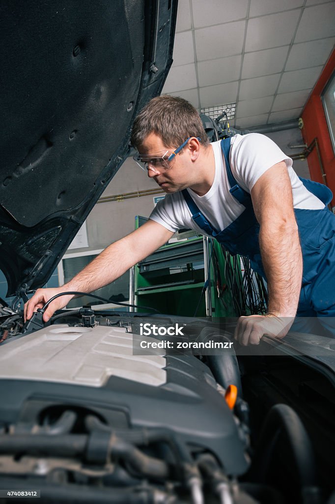 Automotive specialist adjusting an engine Professional car mechanic working in auto repair service 2015 Stock Photo