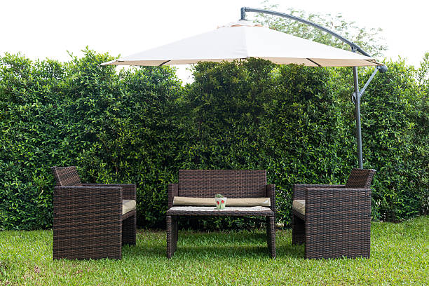 Set of rattan garden furniture under a big garden umbrella stock photo