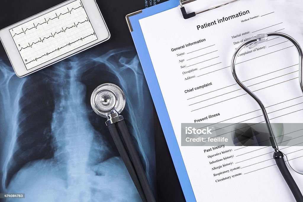 Various medical items such as an x-ray, chart and tablet online medical service:X-ray and Digital Tablet with stethoscope Electrocardiography Stock Photo