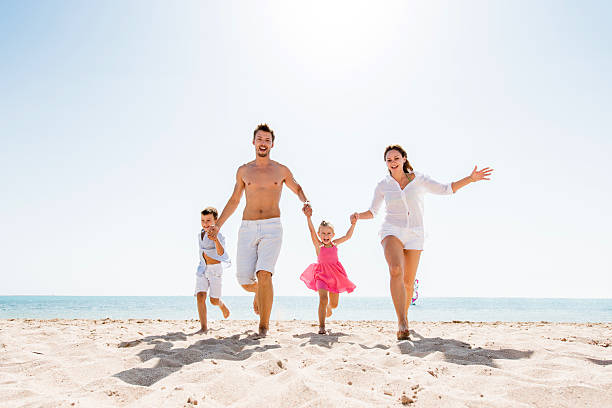 istock Cheerful family running on the beach and having fun. 474085390