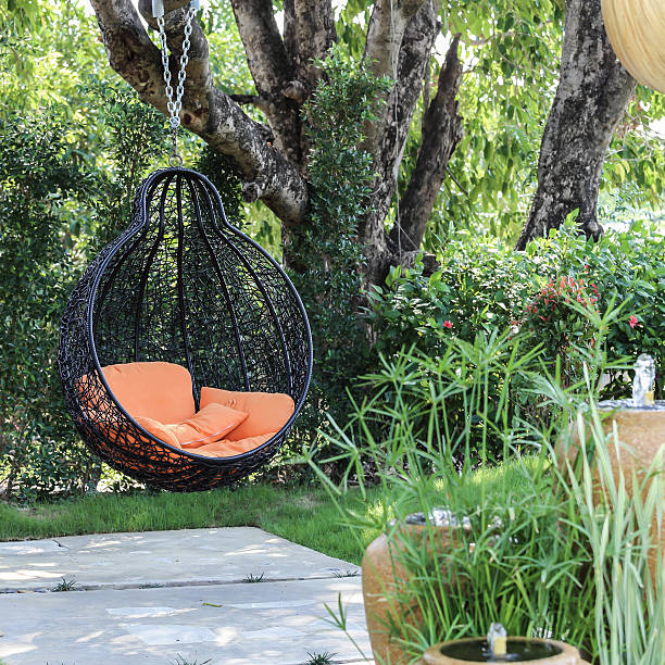 istock Orange pillow on  modern swing in the garden. 474095770