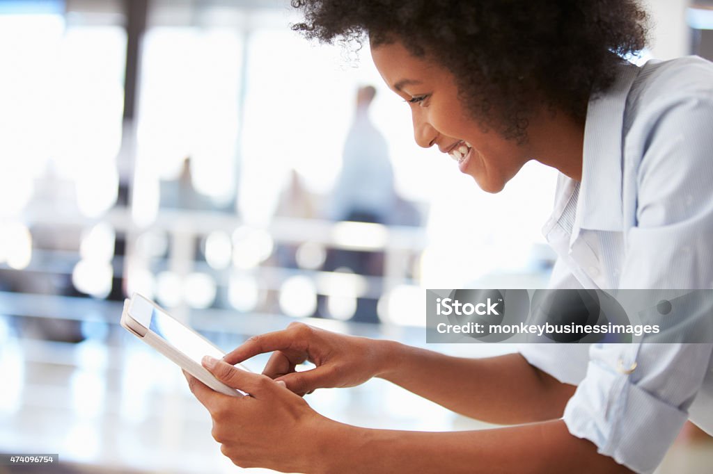 Smiling young woman in an office using a tablet Portrait of smiling woman in office with tablet 20-29 Years Stock Photo