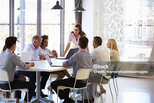 Businesswoman Presenting To Colleagues At A Meeting Stock Photo - Download Image Now