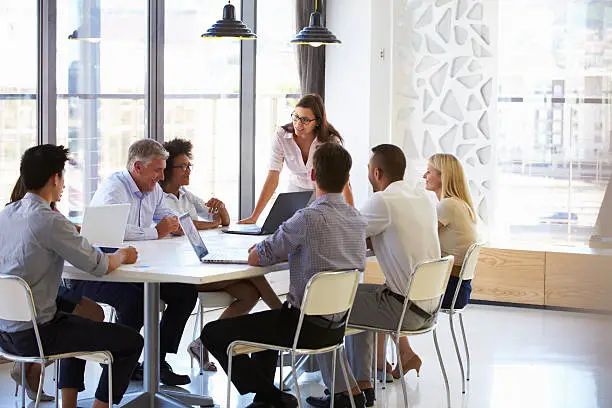 Photo of Businesswoman presenting to colleagues at a meeting