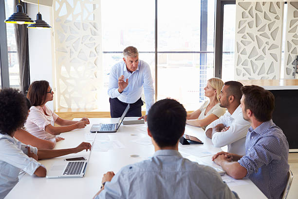 istock Older businessman presenting at a meeting with workmates 474096972