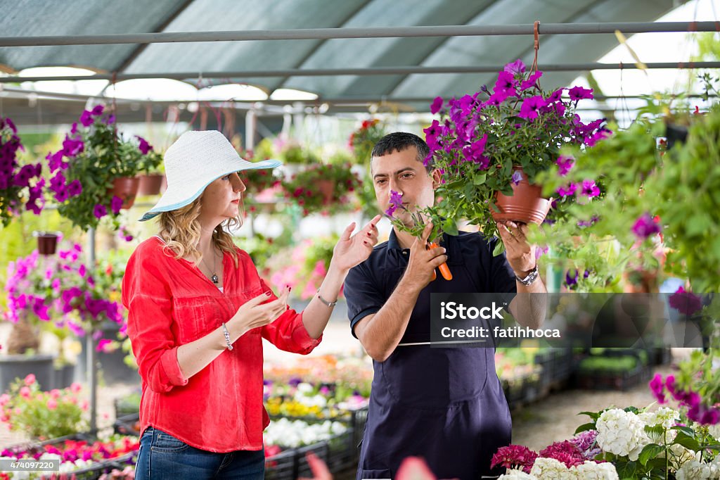 Florist and Customer Florist and customer in greenhouse. 2015 Stock Photo