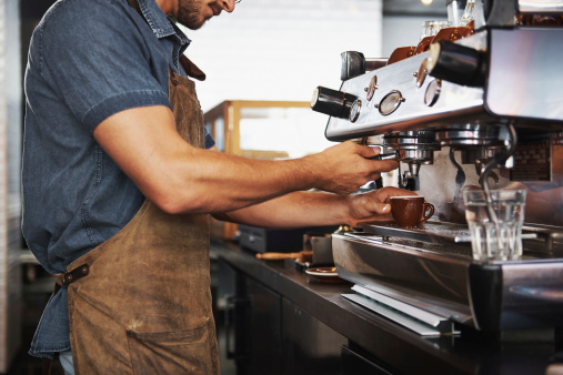 Shot of a male barista making a cup of coffee